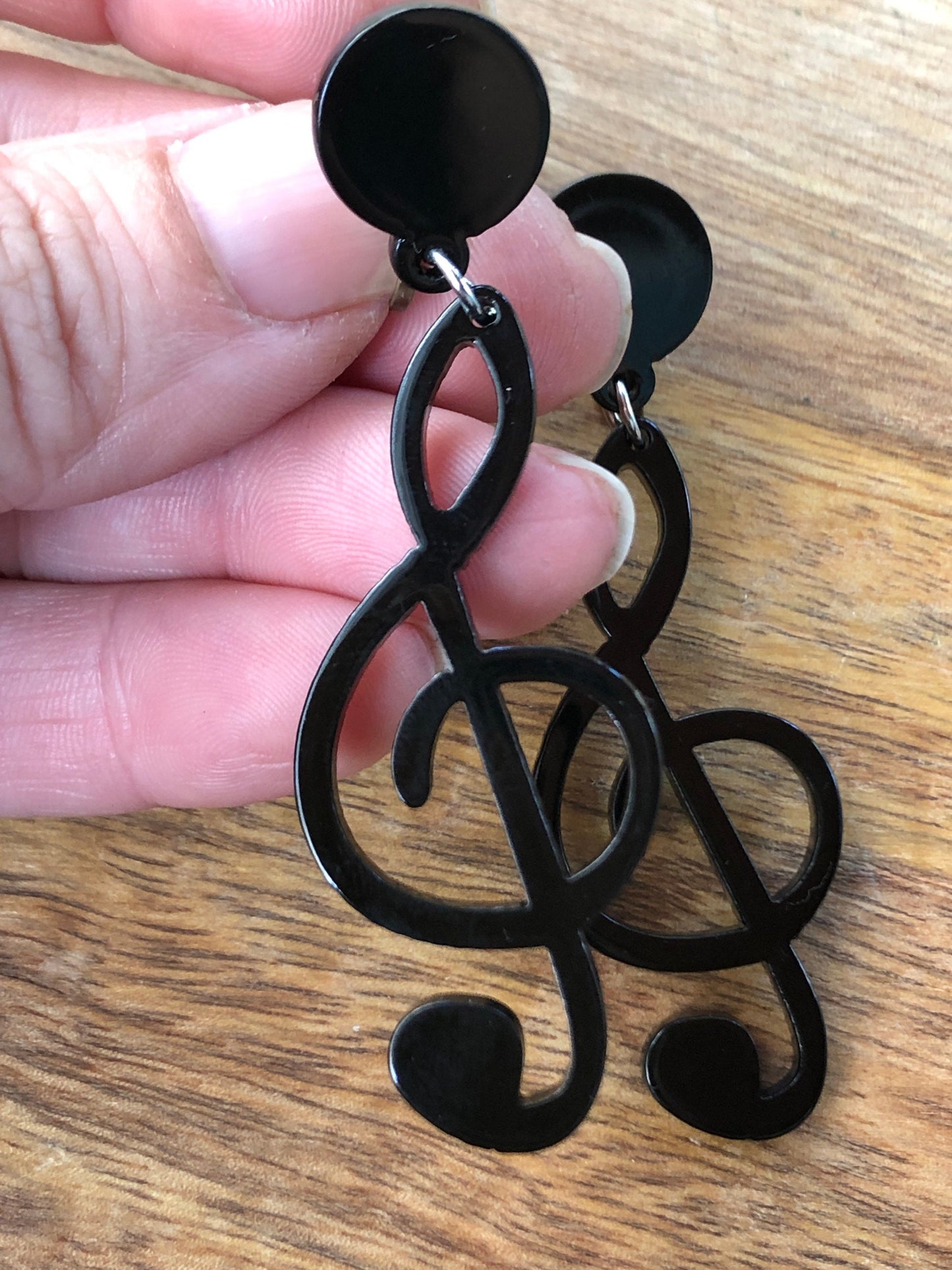 Dangling oversized black plastic treble clef clip on earrings