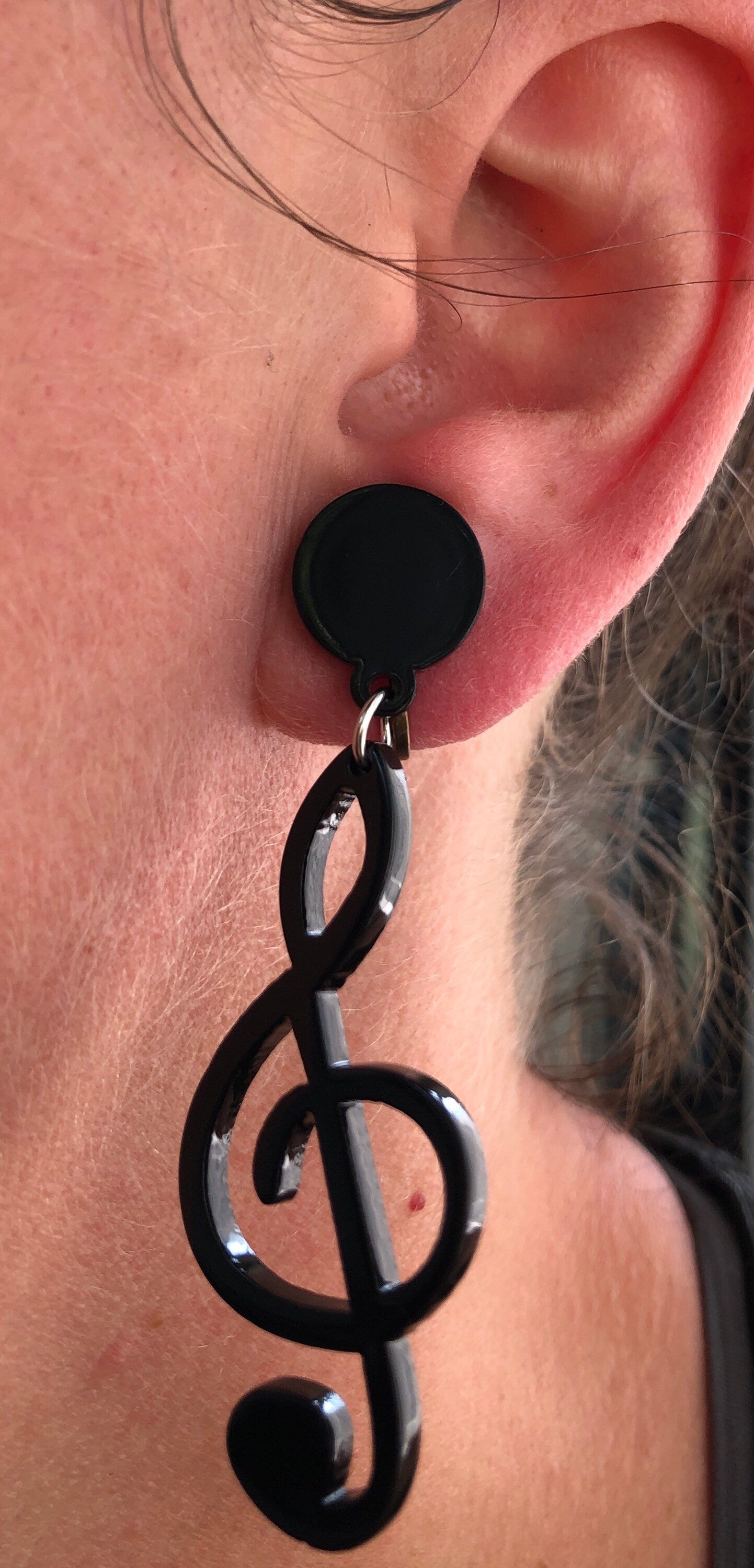 Dangling oversized black plastic treble clef clip on earrings