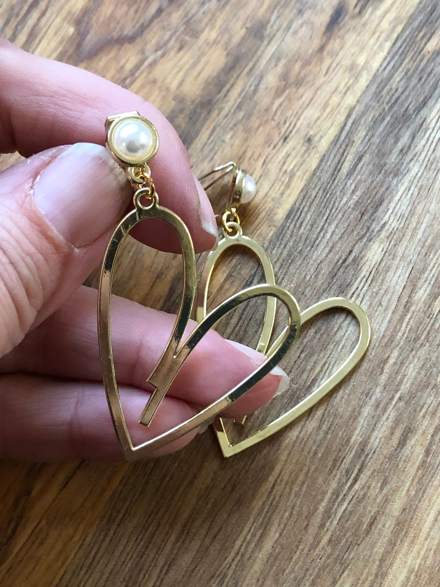 Large clip on dangling gold heart silhouette earrings with faux pearl closures