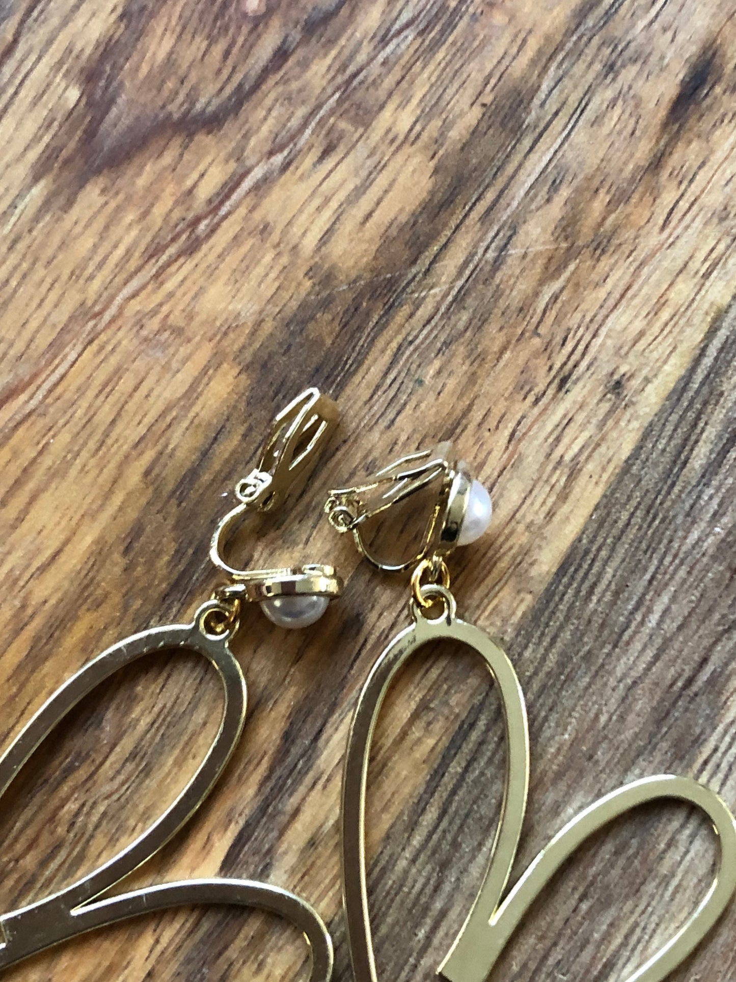 Large clip on dangling gold heart silhouette earrings with faux pearl closures