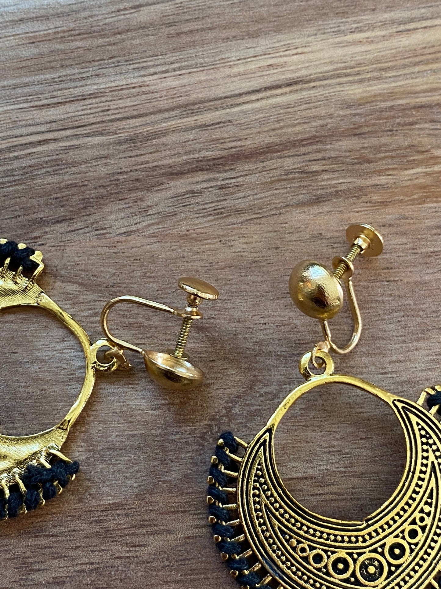 Dangling golden hoop clip on earrings with black accents