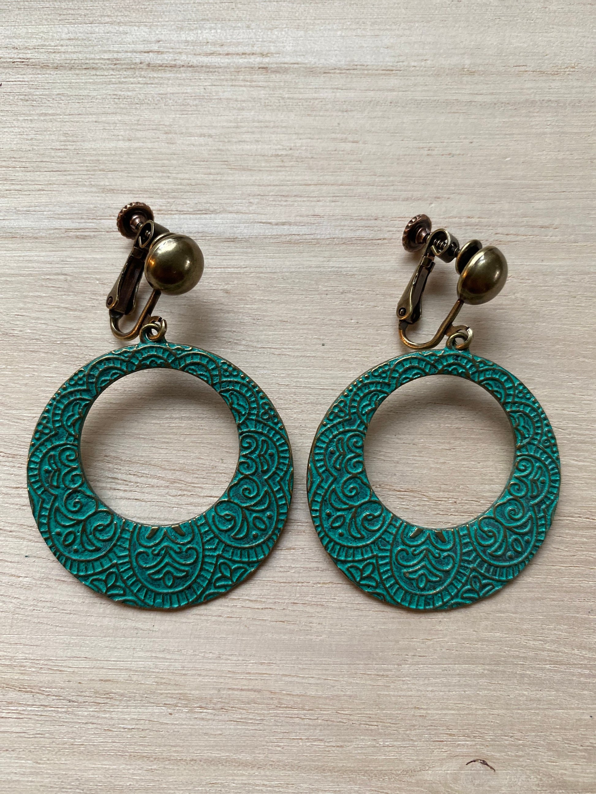 Dangling turquoise clip on hoops, engraved pattern on bronze patina hoops with hinged screwback clip on closures.