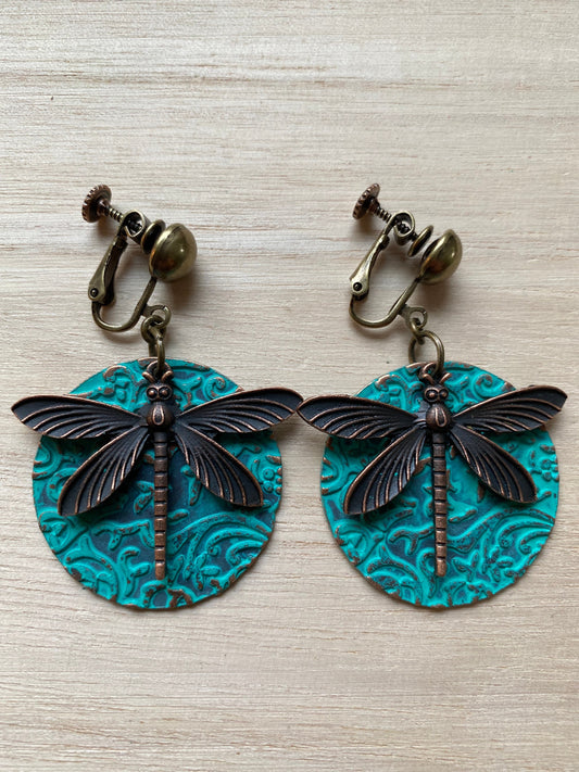 Dangling bronze and turqoise clip on earrings, bronze dragonfly pendant on turquoise medallion with hinged screwback closures for unpierced ears