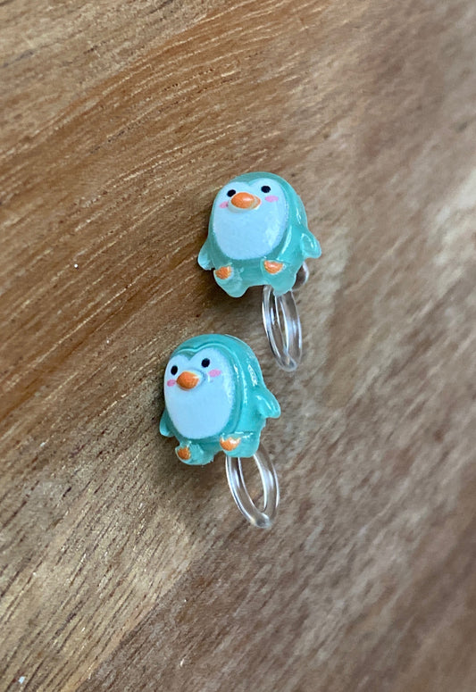 Tiny turquoise penguin plastic earrings on small plastic clips (clips are a plastic cinch that holds tightly to the ear)