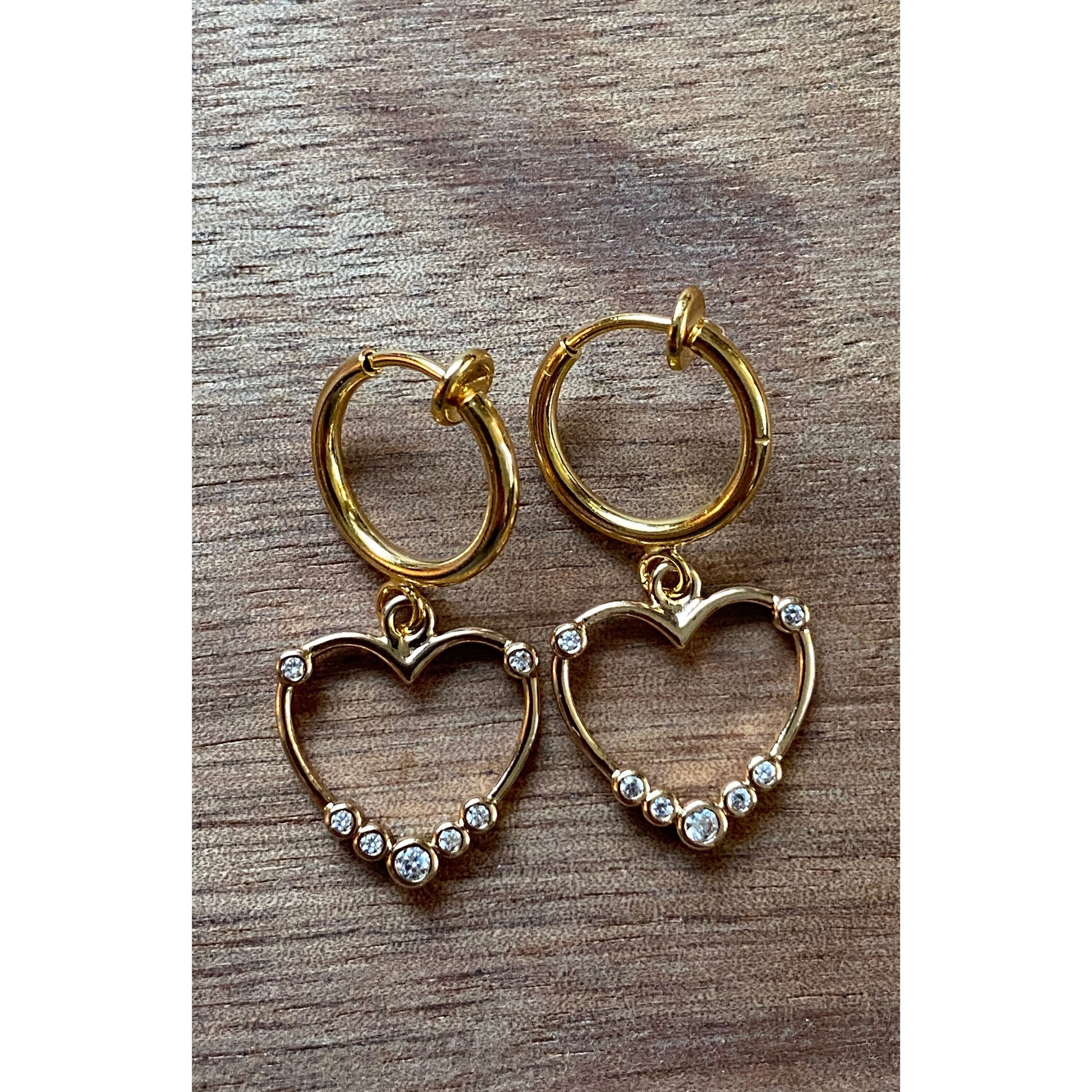 Tiny lightweight wire heart spring hoop earrings for unpierced ears. Little heart pendants have small clear rhinestone adornments, and are on retractable golden spring hoop closures.