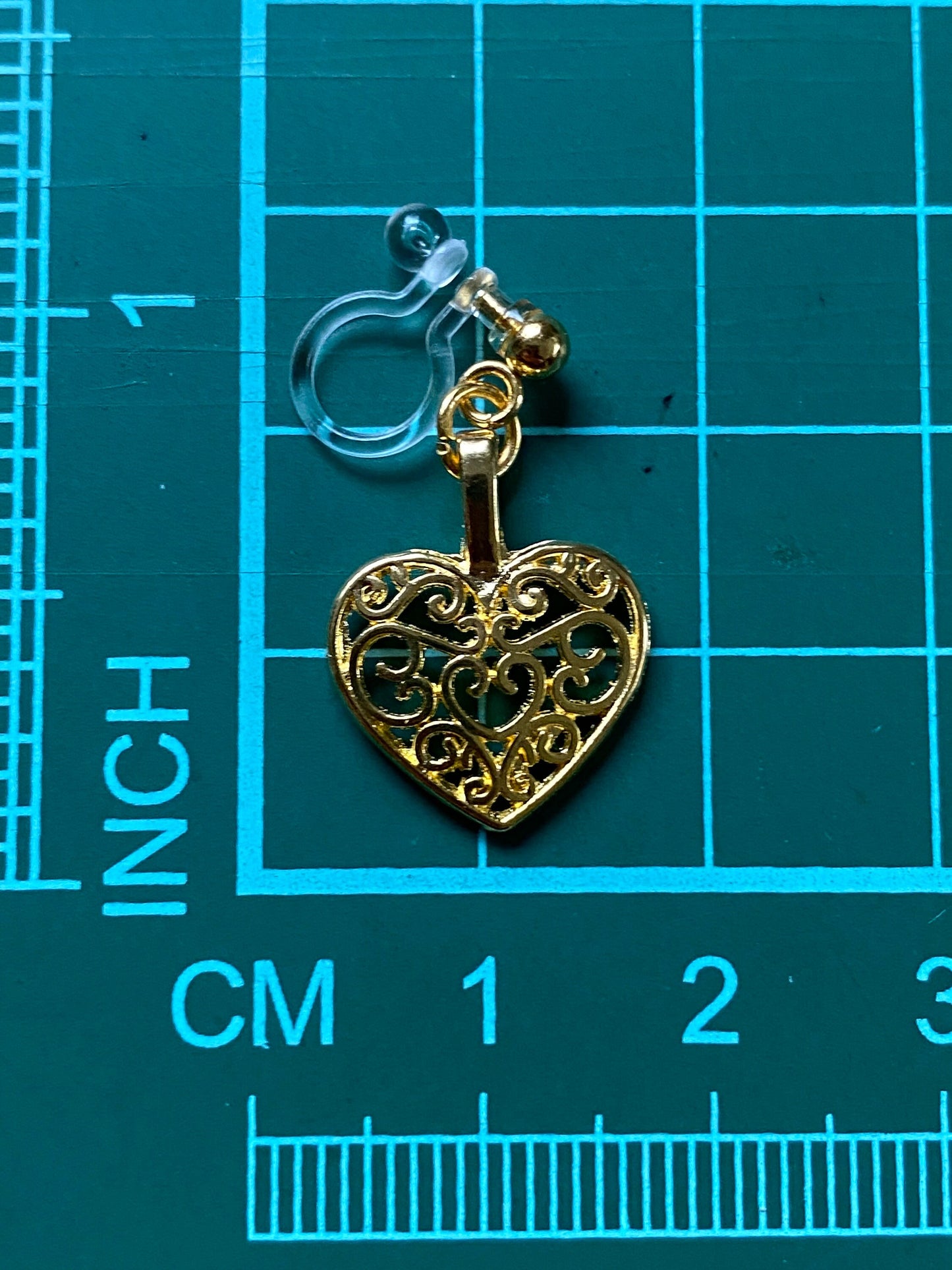 Dangling invisible clip on heart earrings with gold coloured heart pendants