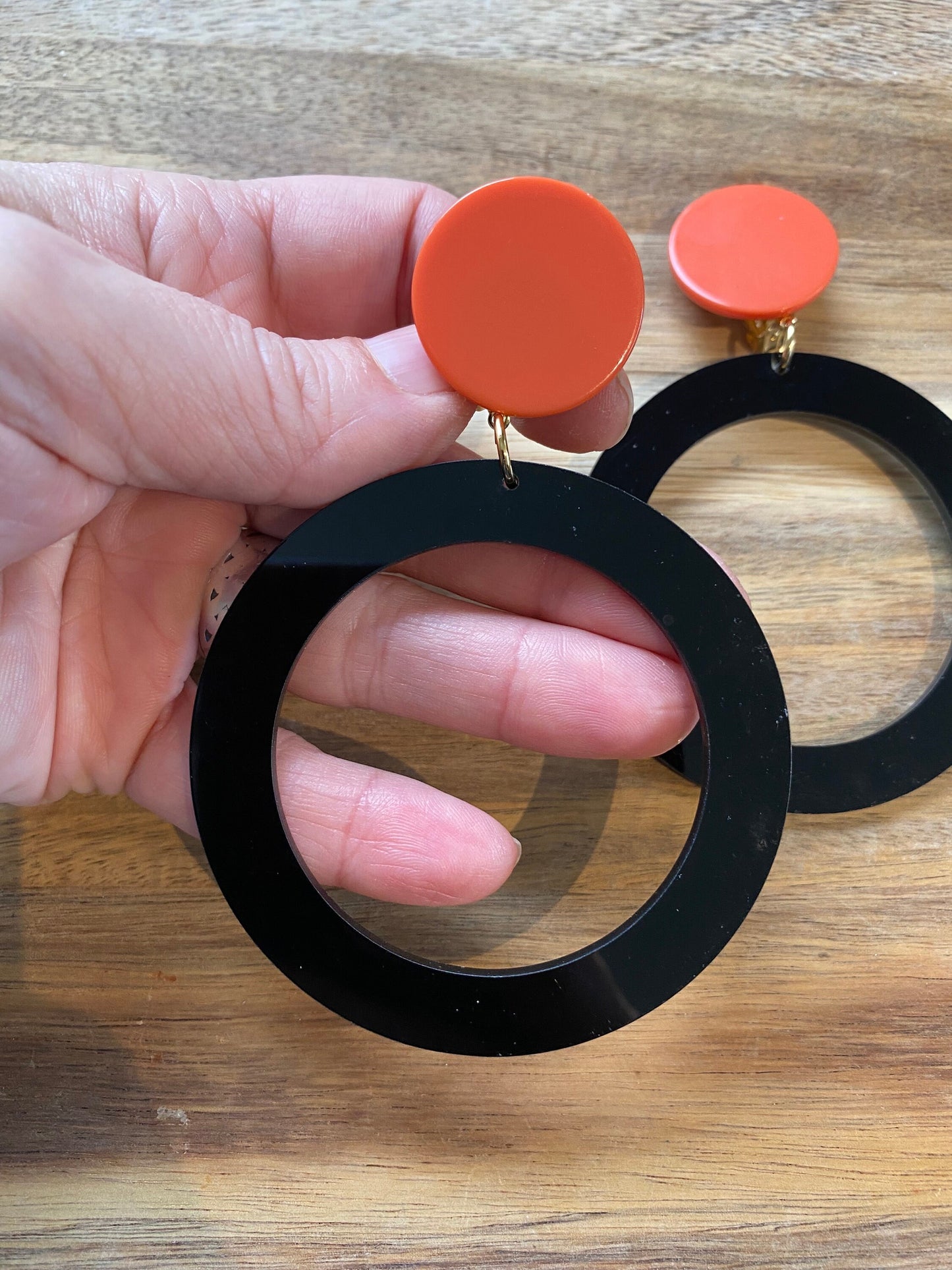 Giant modern clip on drop  plastic hoop earrings, black and tangerine hoops