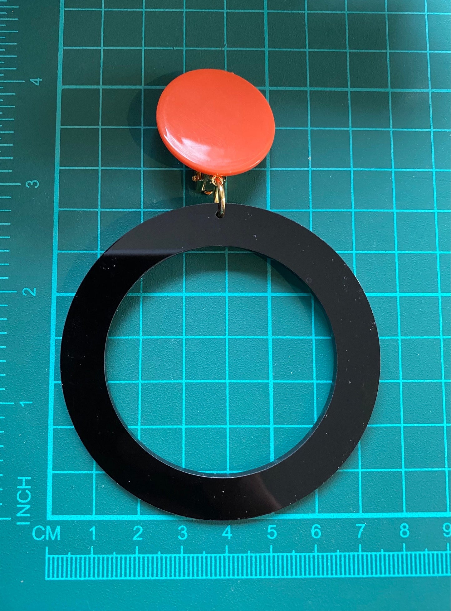 Giant modern clip on drop  plastic hoop earrings, black and tangerine hoops