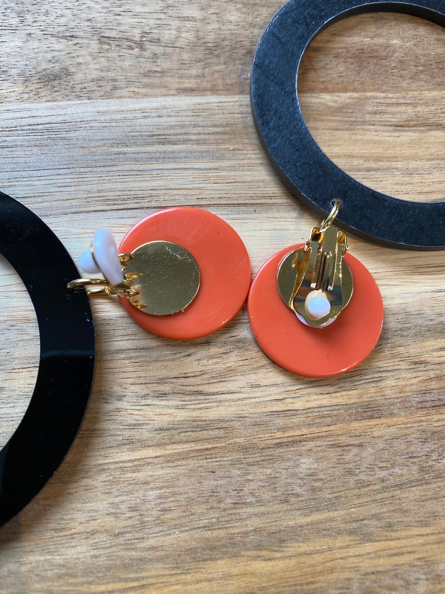 Giant modern clip on drop  plastic hoop earrings, black and tangerine hoops