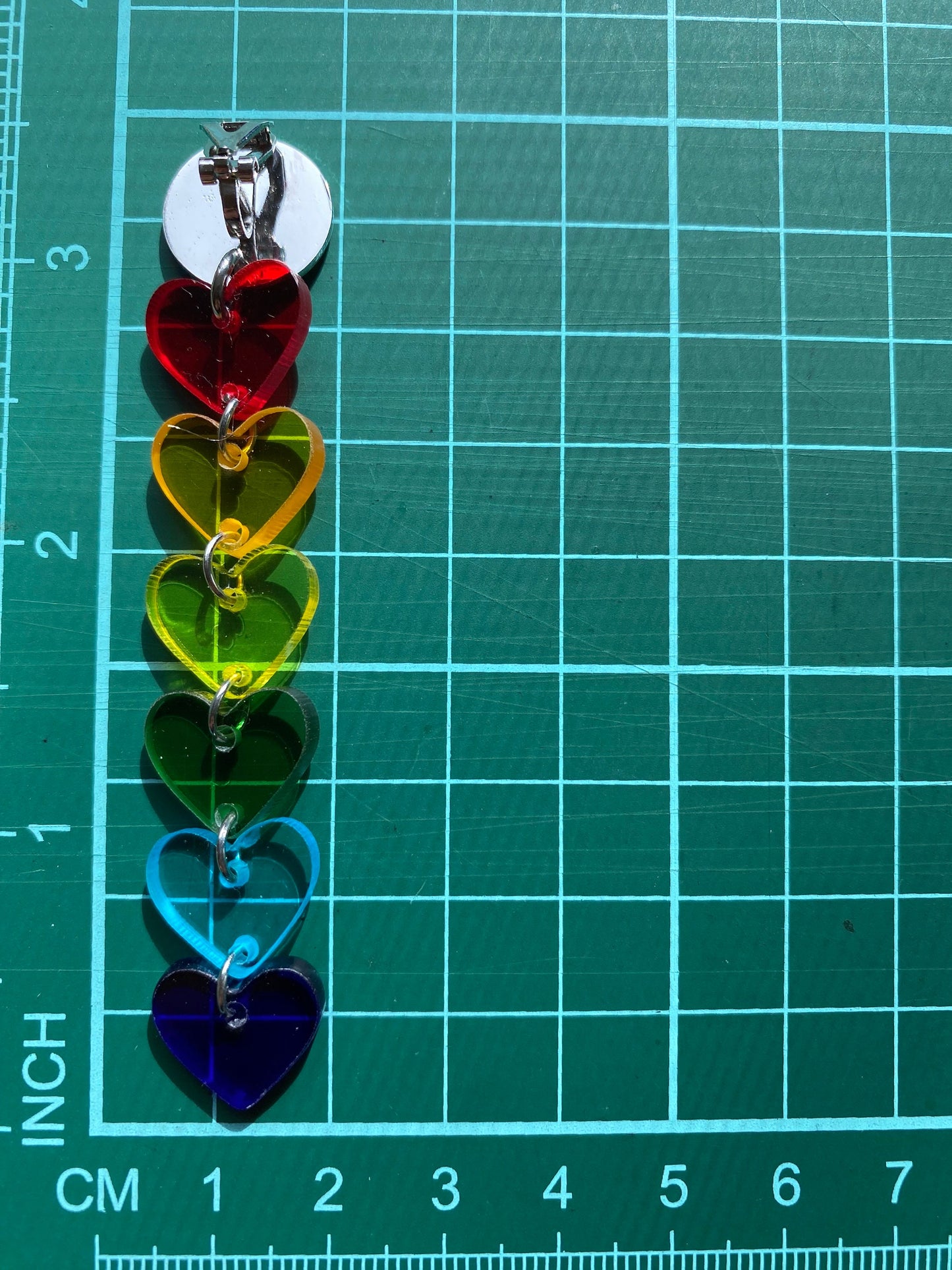 Dangling clip on clear rainbow heart earrings.