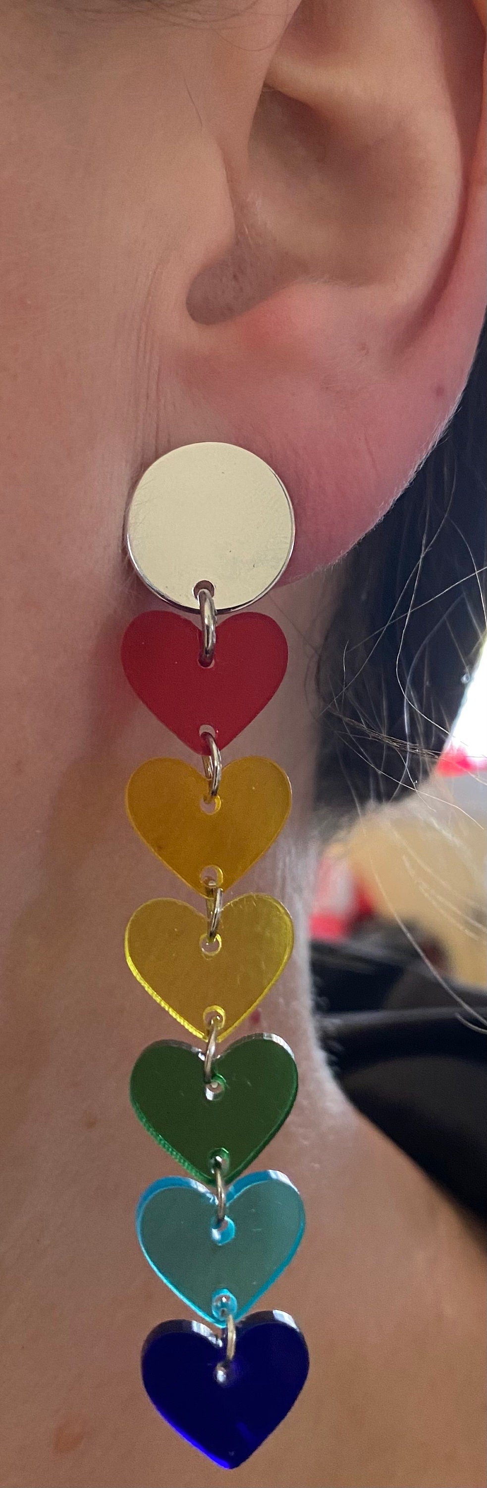 Dangling clip on clear rainbow heart earrings.