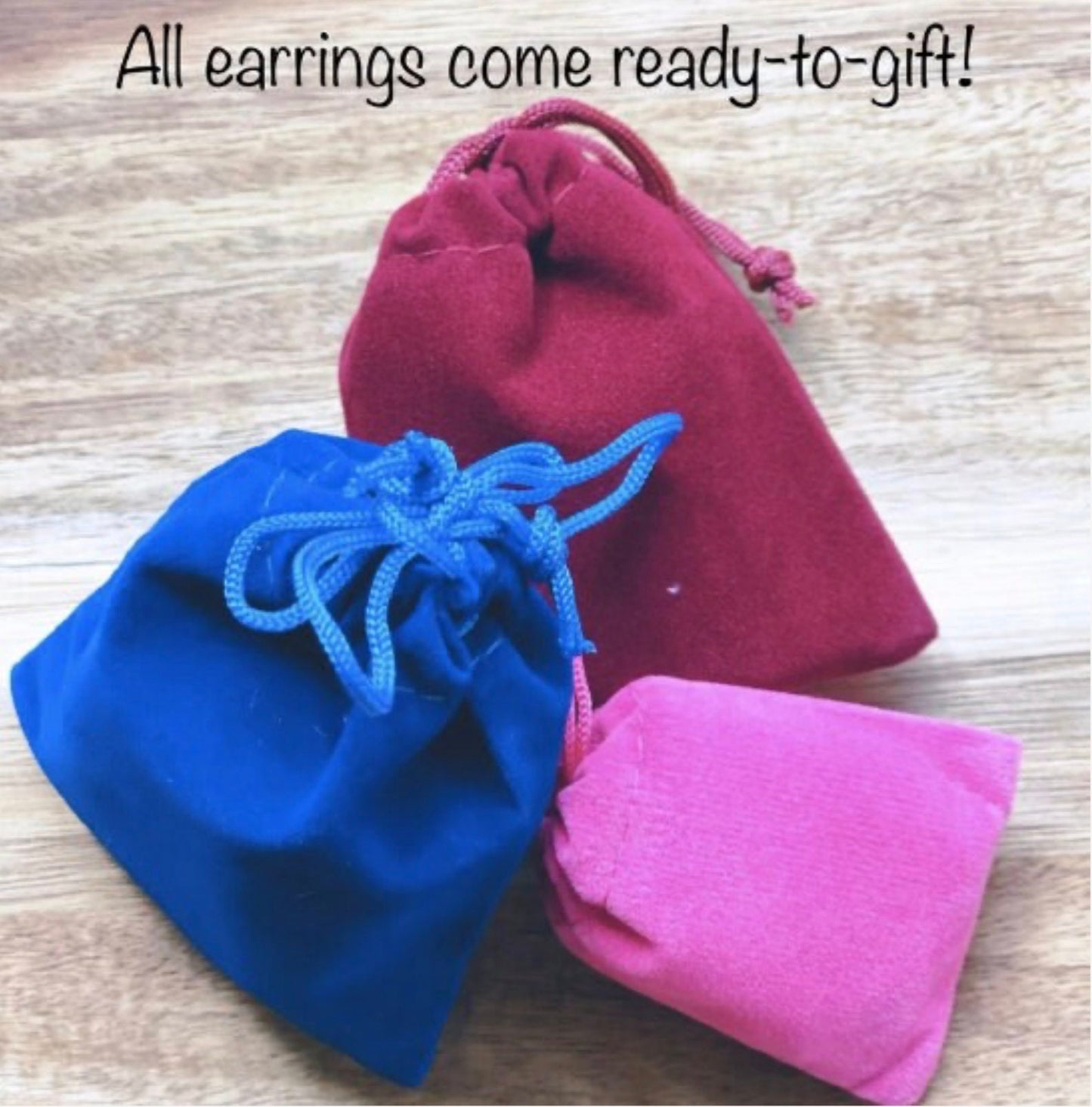 three small pouches sitting on top of a wooden table