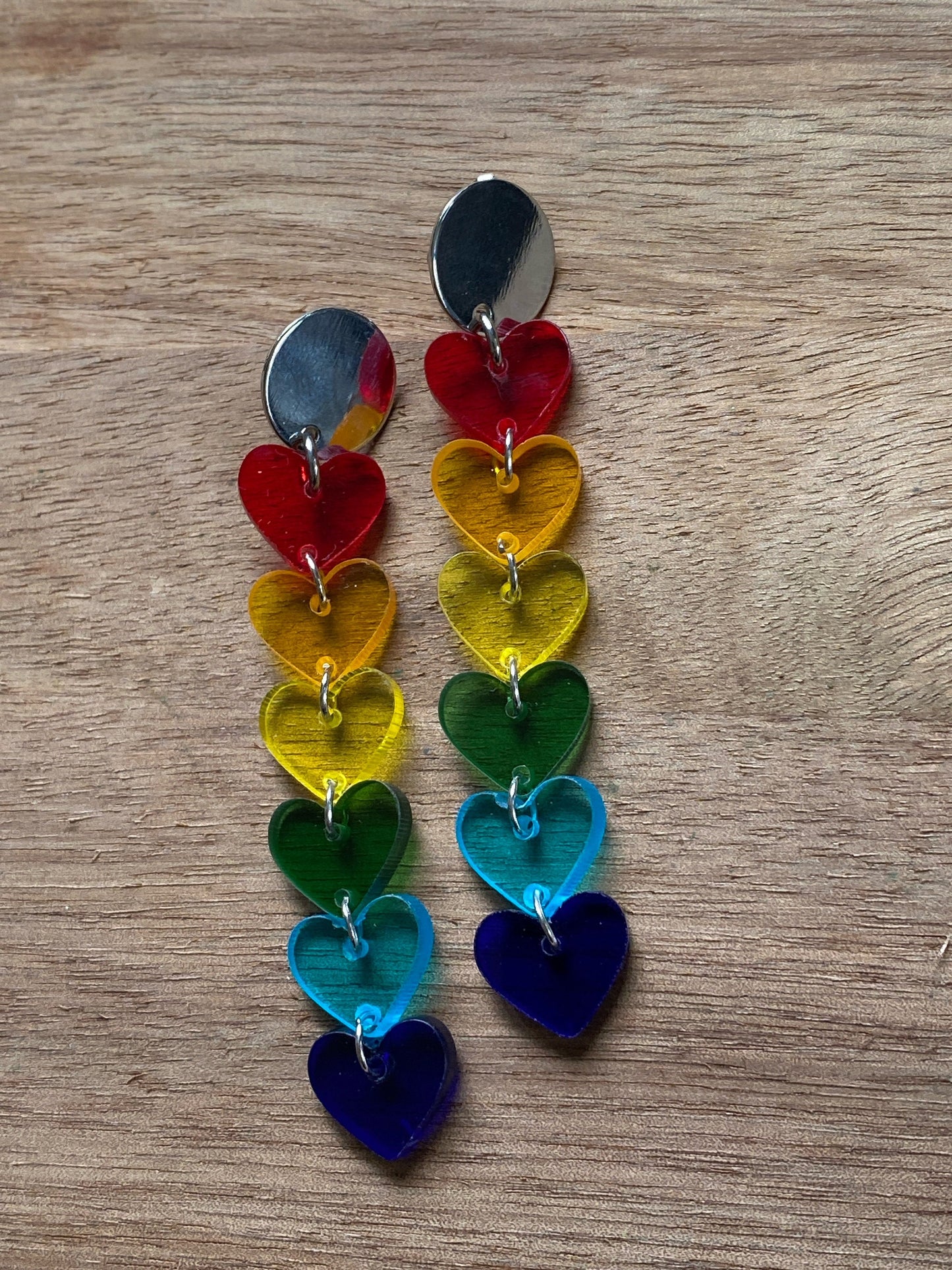 Dangling clip on clear rainbow heart earrings.