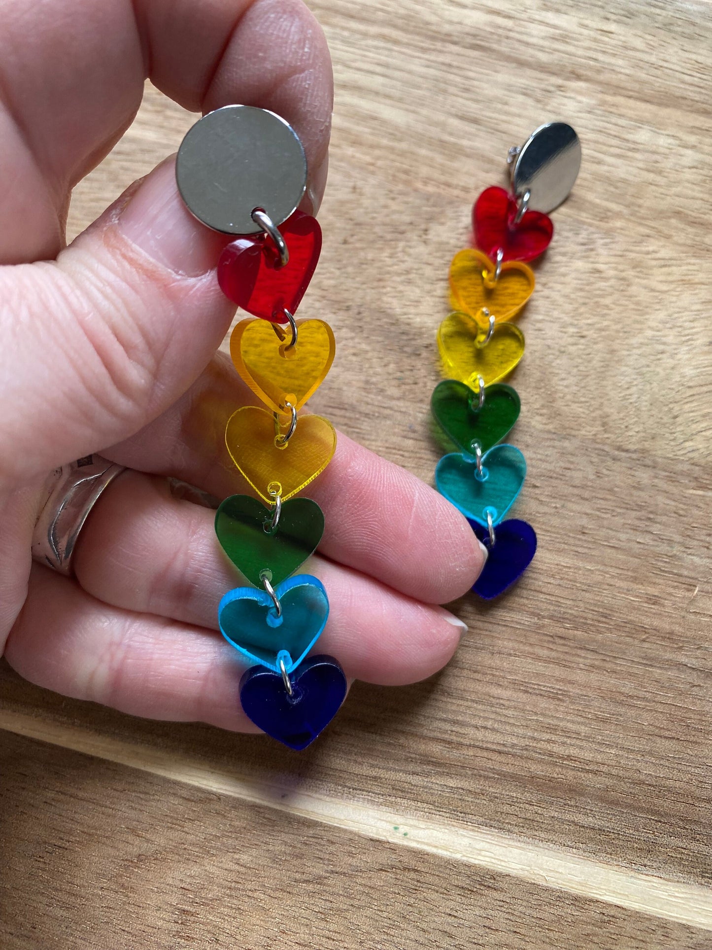 Dangling clip on clear rainbow heart earrings.