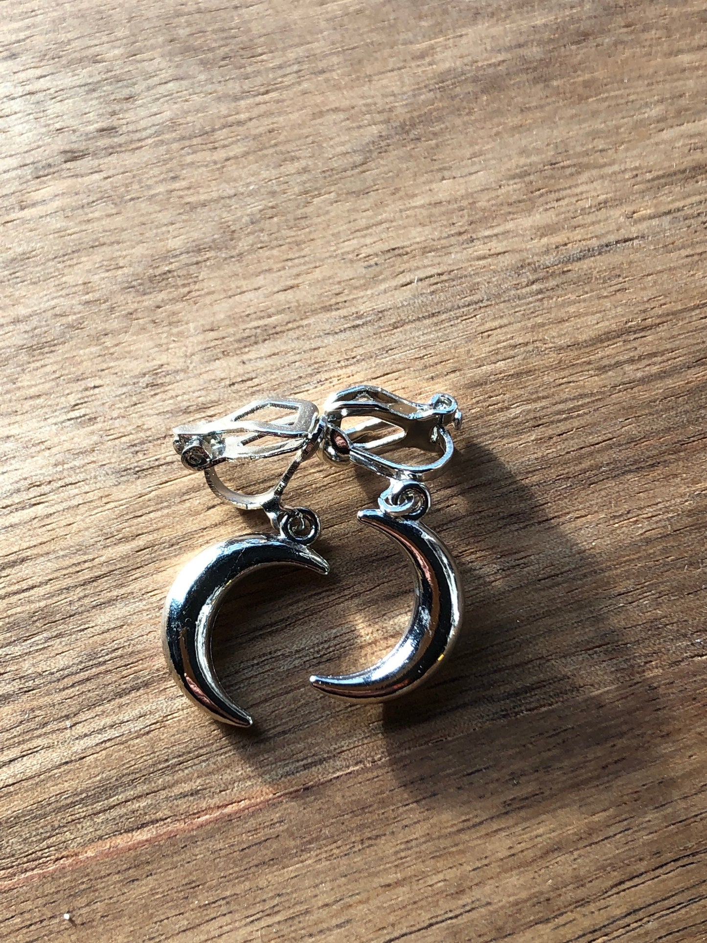 Dangling silver, bronze or gold coloured crescent moon spring hoop (huggie) or clip on earrings